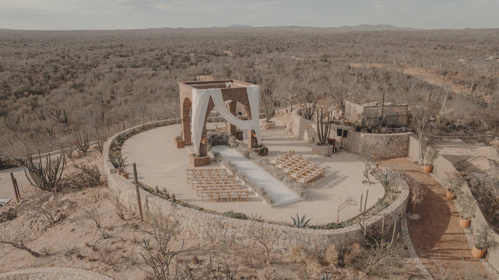 Aerial view of a desert ceremony venue in Los Cabos at golden hour