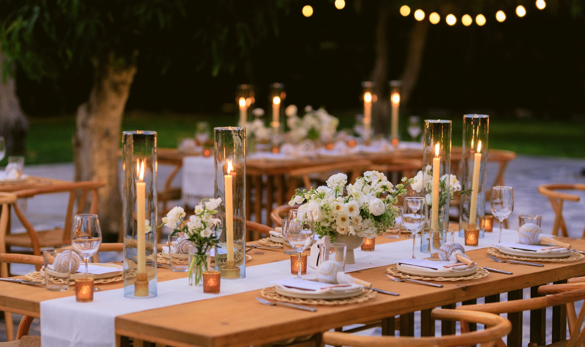 Stunning candlelit long tables under string lights at Acre, Los Cabos