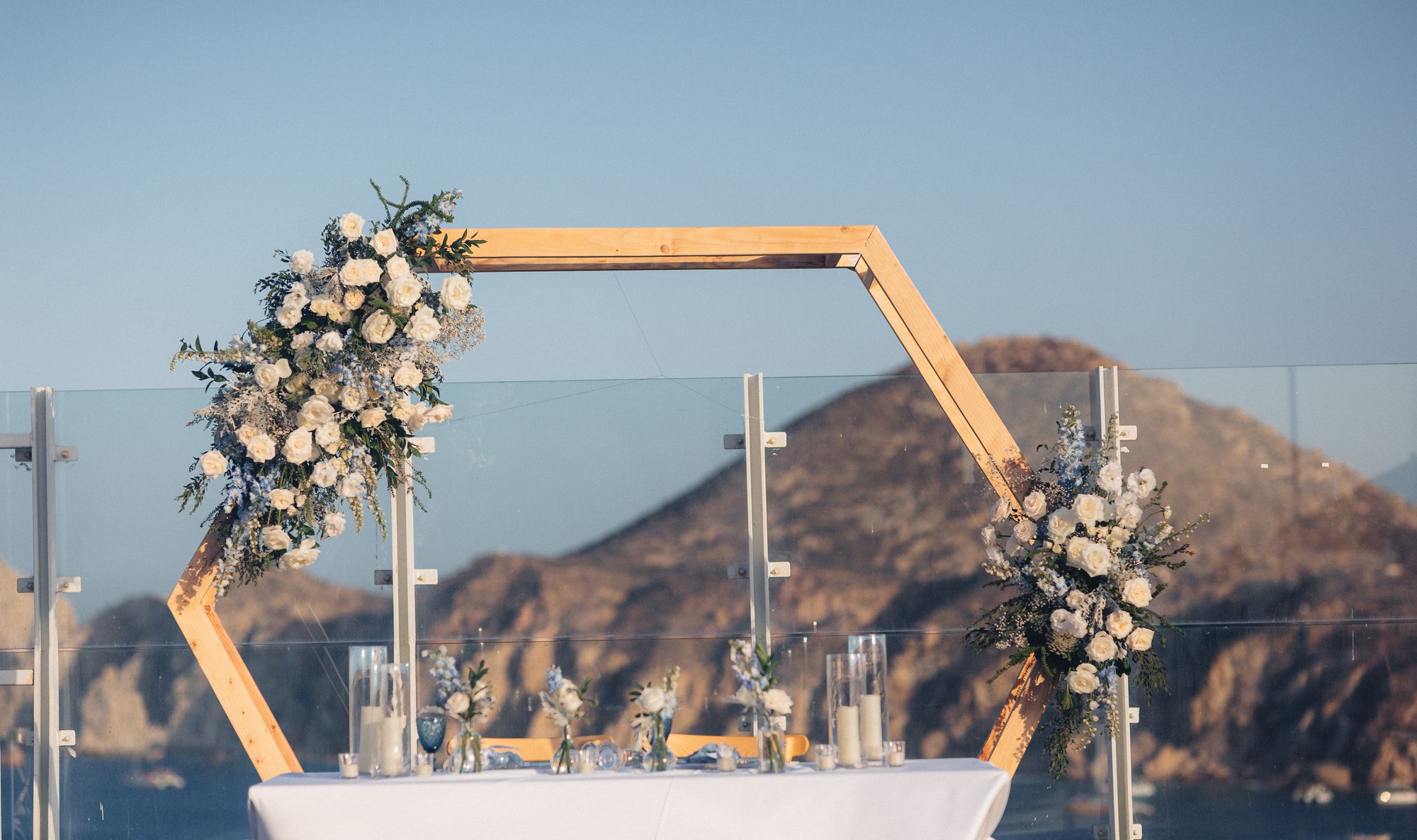 Hexagon floral arch with Land's End behind it on a Los Cabos rooftop