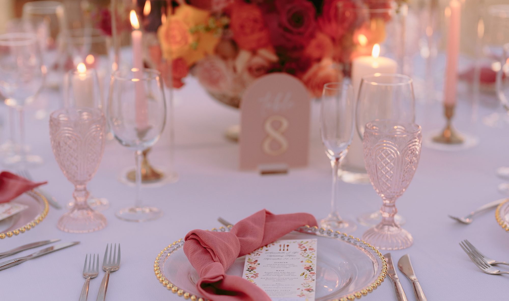 Pink and coral florals with gold-rimmed glassware at Grand Solmar