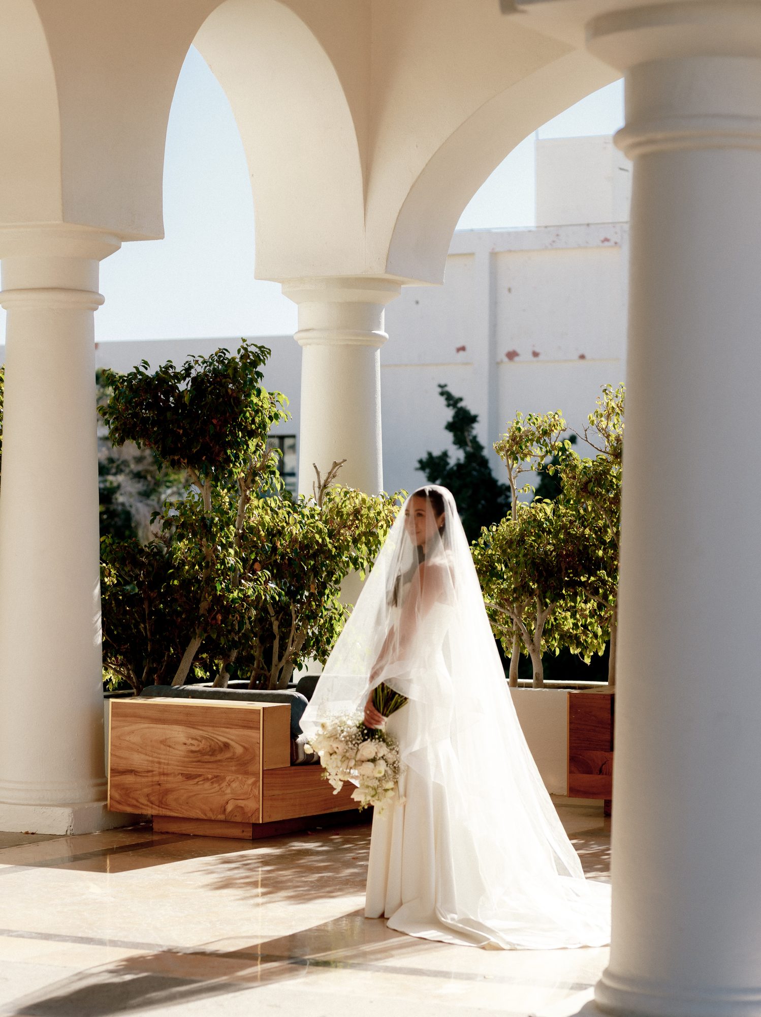 Bride walking through white arches at Hilton Los Cabos