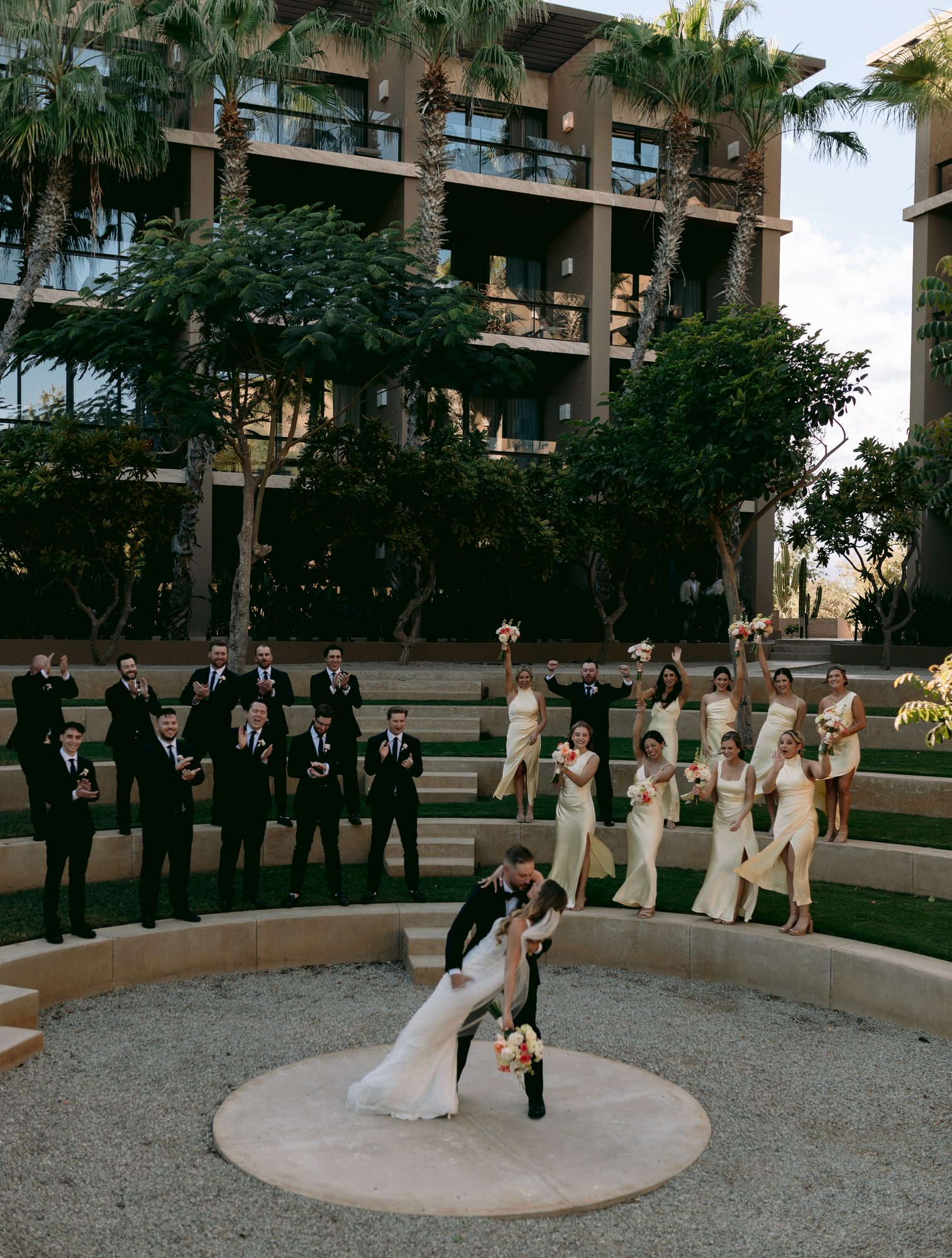 Newlyweds dip in the amphitheater with the wedding party at JW Marriott Los Cabos