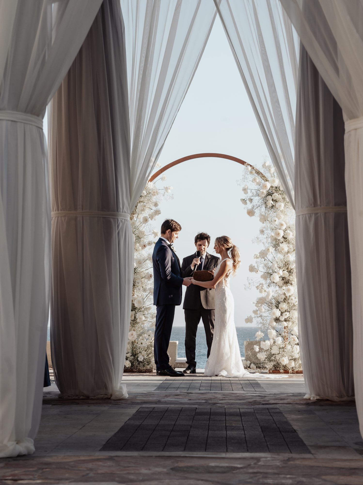 Stunning ceremony between white drapes above the ocean at Waldorf Astoria Pedregal