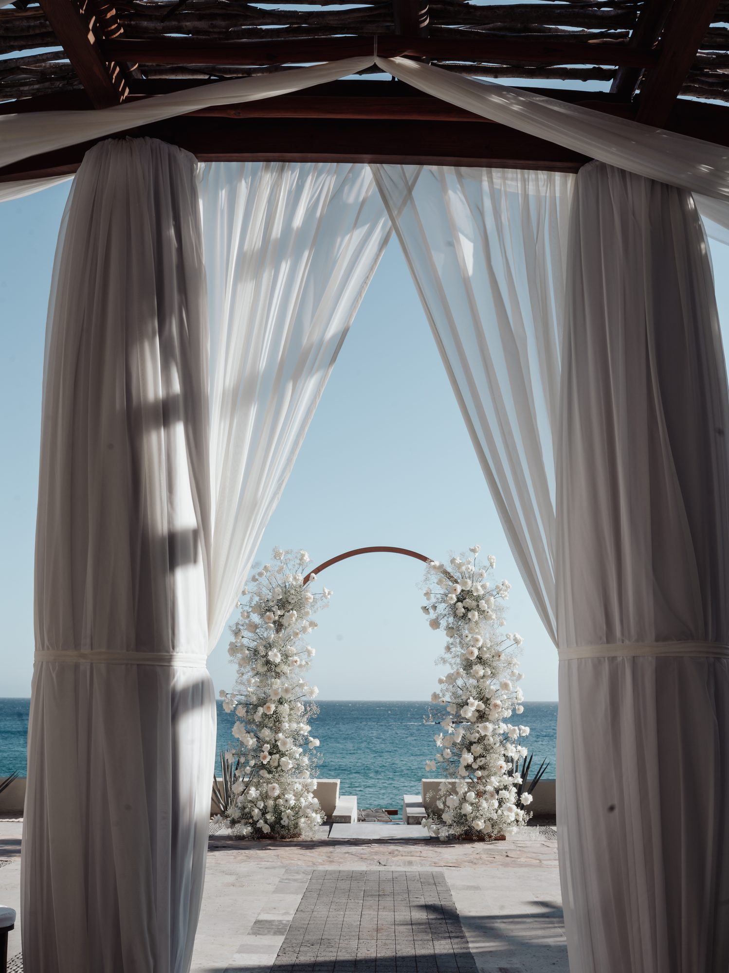 Ceremony arch framed by white drapes at Waldorf Astoria Pedregal