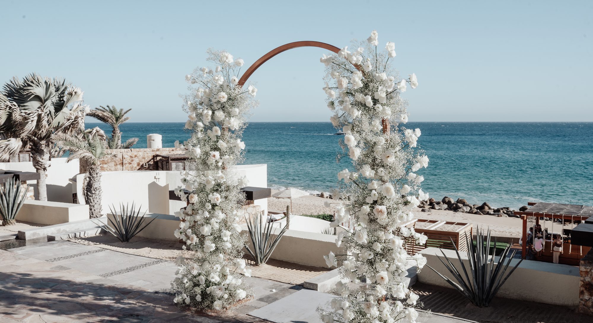 White floral arch above the Sea of Cortez at Waldorf Astoria Pedregal